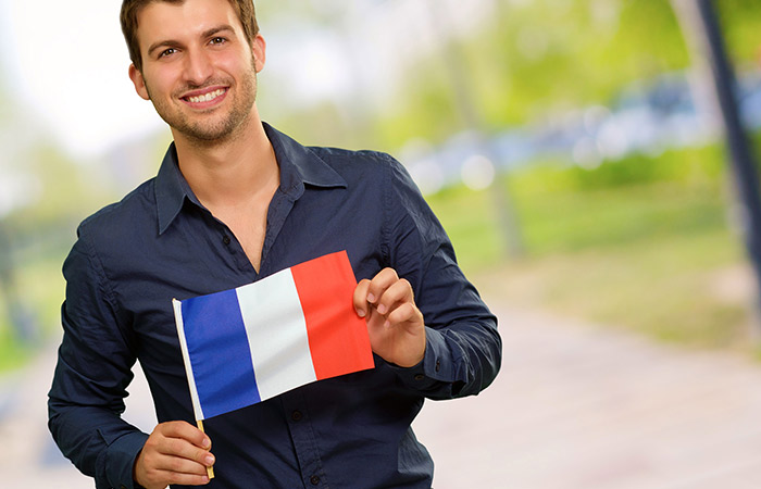 Француз точный. Человек с флагом Франции. Мужчина с флагом Франции. Мужчина с флажком. Молодой парень с флагами.