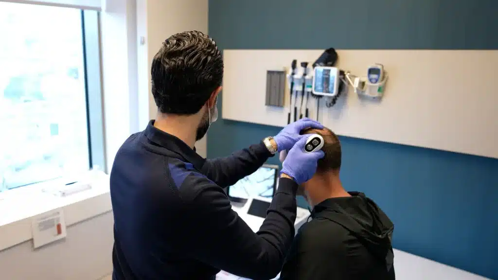 Spécialiste Clinicana examinant la zone donneuse d’un patient au trichoscope numérique